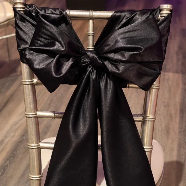 Black satin bow tied on a gold Chiavari chair at a wedding in Oklahoma City