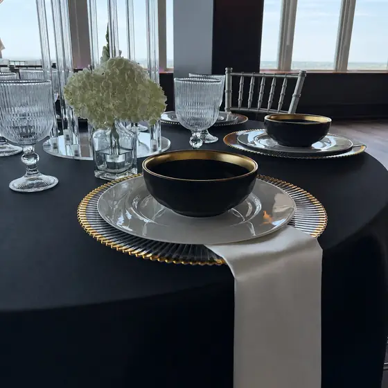 Black and gold service on a black satin round